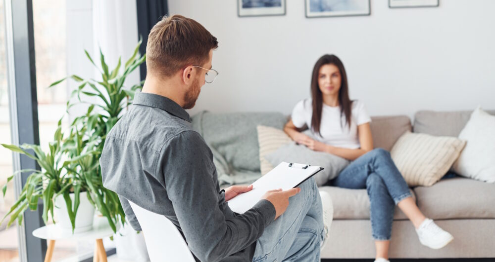 Young woman at a reception at a psychologist. Sits on the sofa.